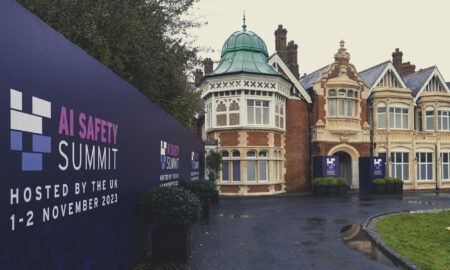 Bletchley Park Mansion alongside blue signage saying 'AI Safety Summit'